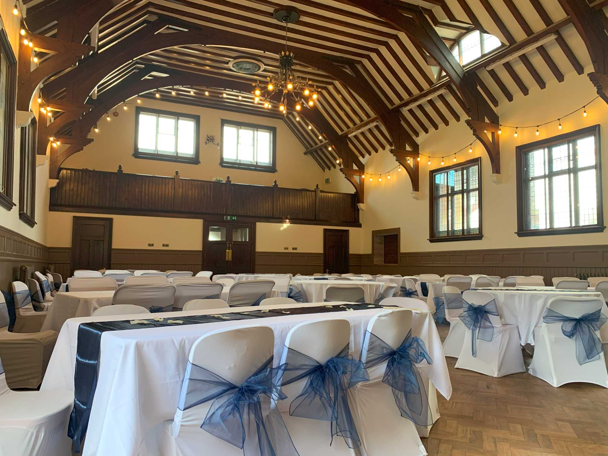 Waddesdon Hall function room set for an event with white chair covers and navy sashes.