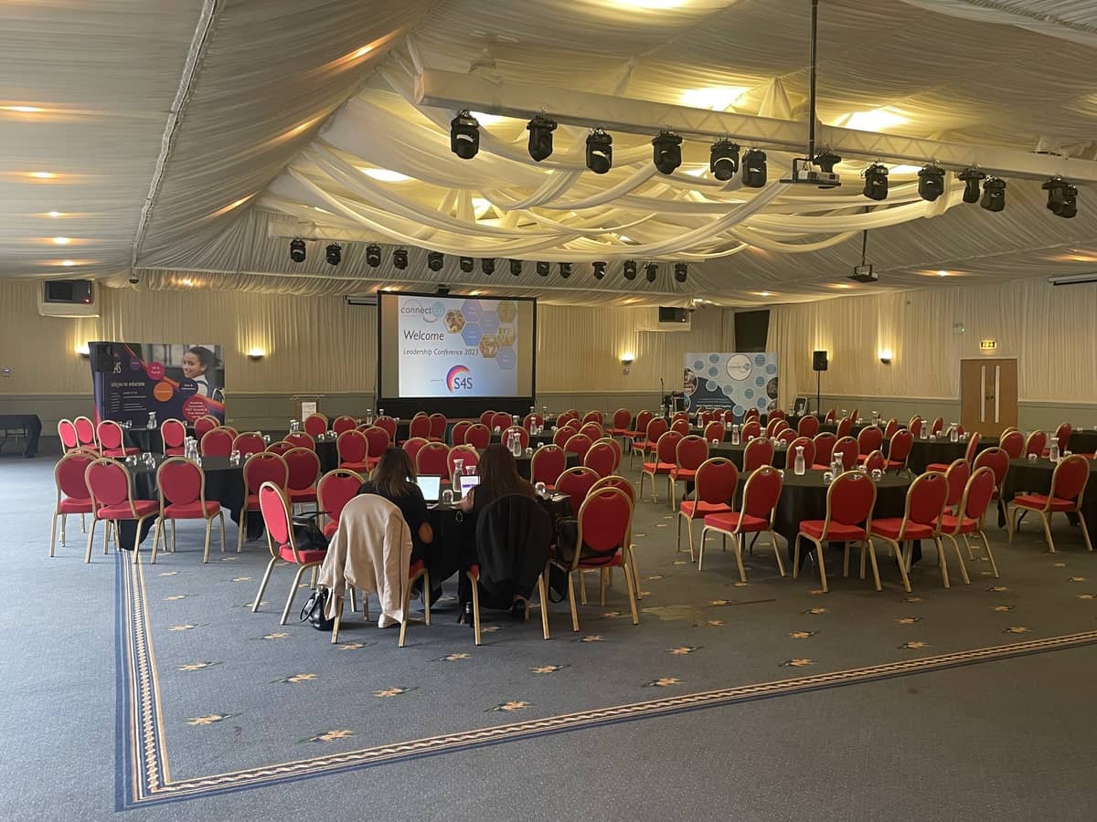 Large conference room set up with red chairs and a projection screen at Wolverhampton Racecourse.